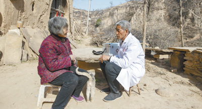 張尚保(右)正在為村民講解健康知識。 張尚保(右)正在為村民講解健康知識。