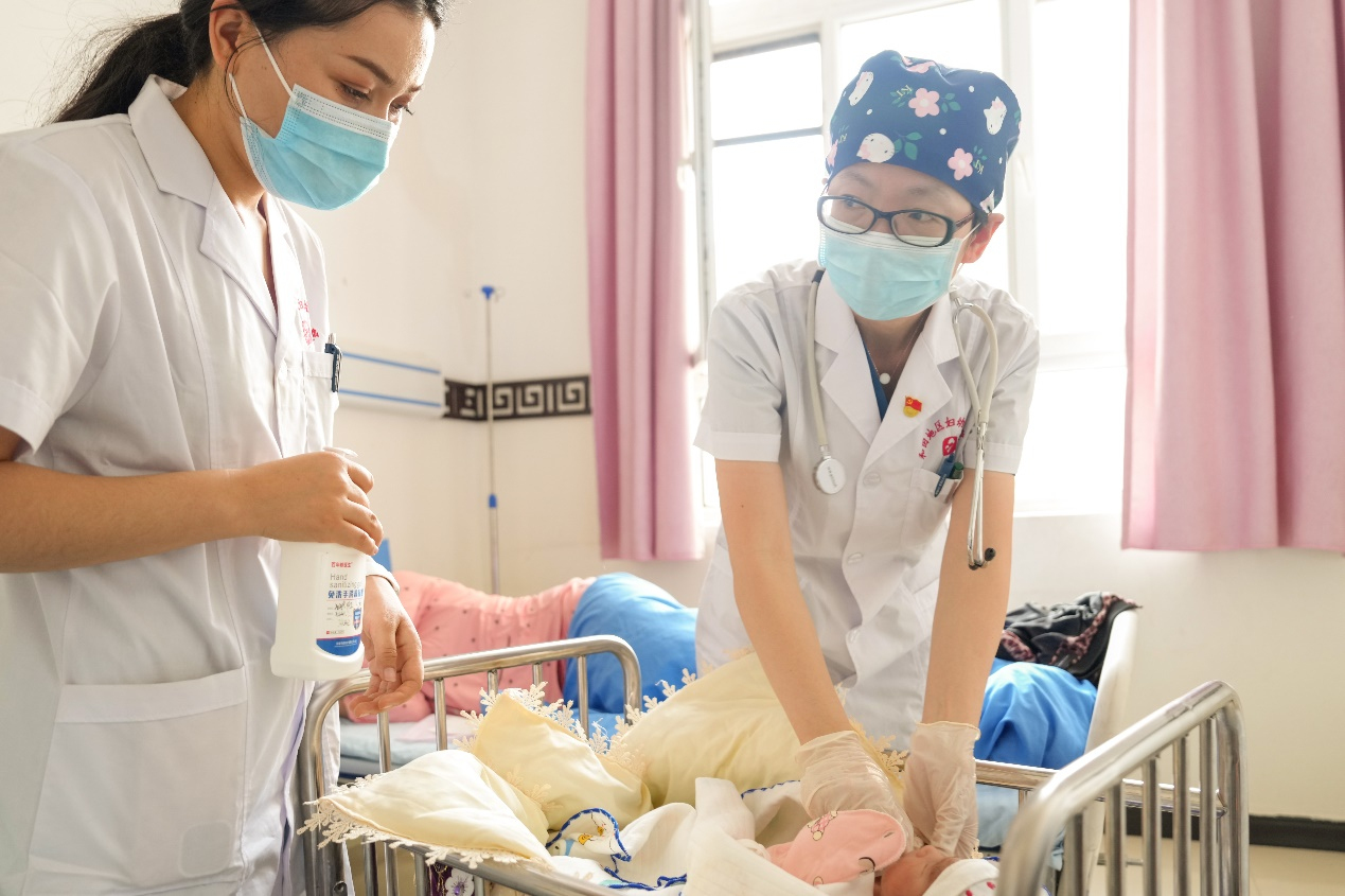 在和田地區婦幼保健院掛職兒童保健部第一主任的北京婦產醫院援疆醫生王淑榮（左二）在進行教學查房，講解新生兒體格檢查注意事項。