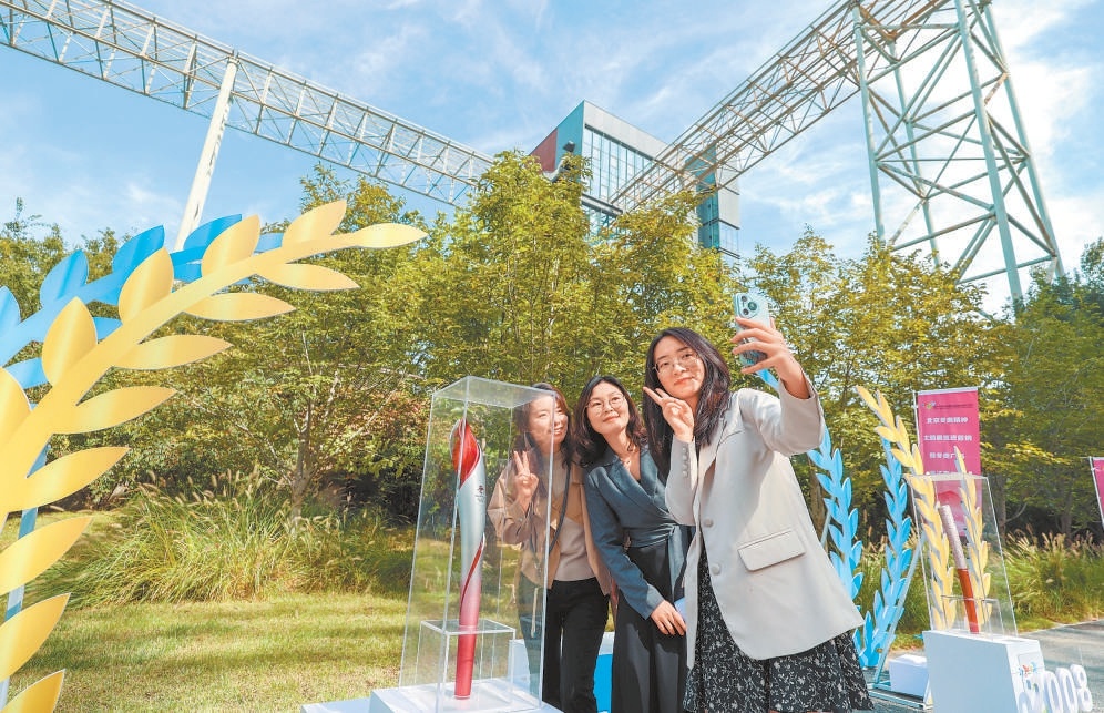 圖為在冬奧精神主題展上,遊客和冬奧會火炬合影。 圖為在冬奧精神主題展上,遊客和冬奧會火炬合影。