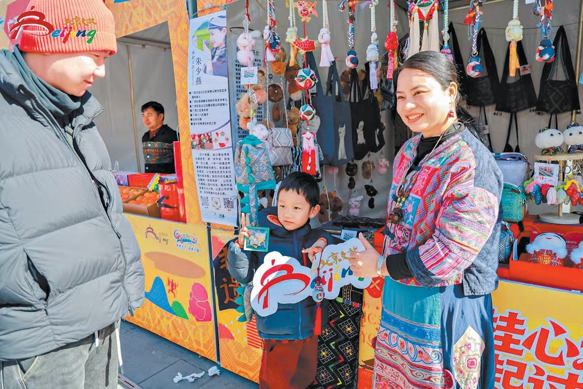 朝外商圈廟會展位上,身著民族服裝的工作人員向遊客介紹廣西特色手工藝品。 朝外商圈廟會展位上,身著民族服裝的工作人員向遊客介紹廣西特色手工藝品。