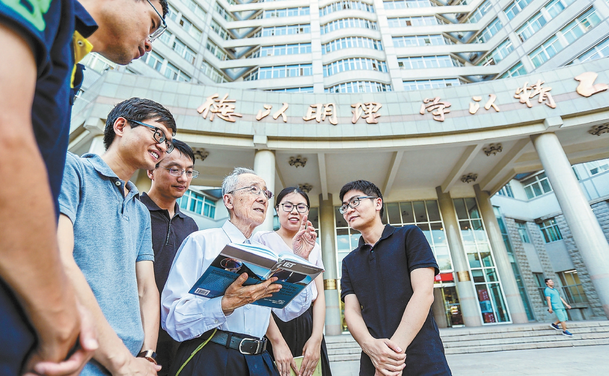 毛二可院士（中）在北京理工大學校園內與同事和學生交流。