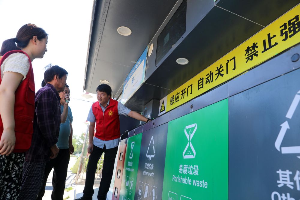 在安徽省合肥市長豐縣莊墓鎮棗林社區,誌願者指導居民使用智能垃圾分類回收設備(2023年9月1日攝)。 在安徽省合肥市長豐縣莊墓鎮棗林社區,誌願者指導居民使用智能垃圾分類回收設備(2023年9月1日攝)。