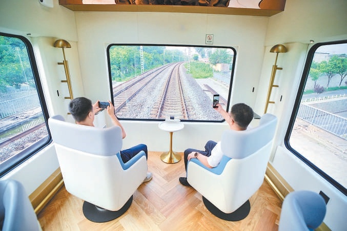 旅客通過“星光·燕趙號”列車的超大觀景窗賞景。