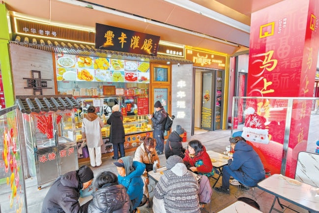 2月12日,在隆福寺豐年灌腸店鋪,市民遊客品嚐北京特色小吃。 2月12日,在隆福寺豐年灌腸店鋪,市民遊客品嚐北京特色小吃。