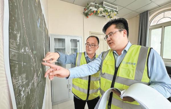 1月31日,劉太訓(右)和同事正在研究施工方案。 1月31日,劉太訓(右)和同事正在研究施工方案。