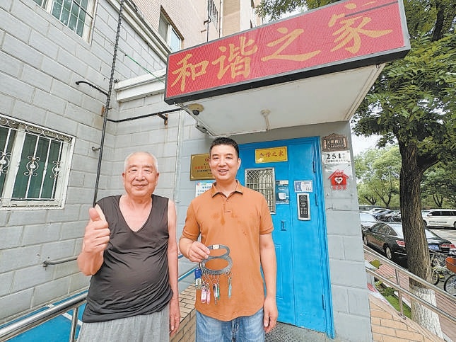 周治國（右）幫鄰居保管鑰匙。